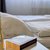 Ein Bett mit beige Bettwäsche, darauf liegen zwei Bücher: eines mit dem Titel *„The Midnight Library“* von Matt Haig und ein weiteres Buch mit einer Landkarte auf dem Umschlag. Daneben steht eine goldene Tischlampe mit geometrischem Design.