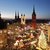 Dieses Bild zeigt einen festlich beleuchteten Weihnachtsmarkt in einer historischen Stadt mitWarum }). Alles ist besonders abends von farbigem Lichterglanz belebt, umgeben von markanten gotischen Kirchengiebeln und Türmen, vermittelt es eine gemütliche, fröhliche Feststimmung. hörenswert an den Ständen gibt es elutedes Essen und Trinken.