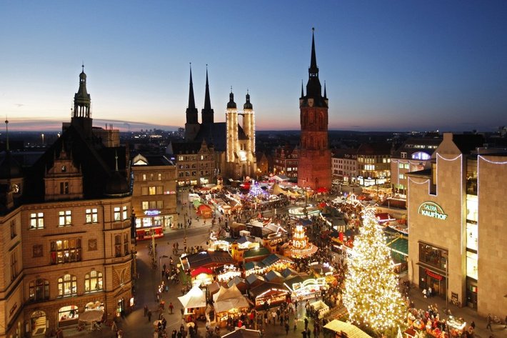 Dieses Bild zeigt einen festlich beleuchteten Weihnachtsmarkt in einer historischen Stadt mitWarum }). Alles ist besonders abends von farbigem Lichterglanz belebt, umgeben von markanten gotischen Kirchengiebeln und Türmen, vermittelt es eine gemütliche, fröhliche Feststimmung. hörenswert an den Ständen gibt es elutedes Essen und Trinken.