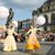 Zwei Frauen in traditioneller Tracht tanzen vor Publikum auf einem öffentlichen Platz, jede hält einen großen weißen Luftballon mit der Aufschrift „München“.